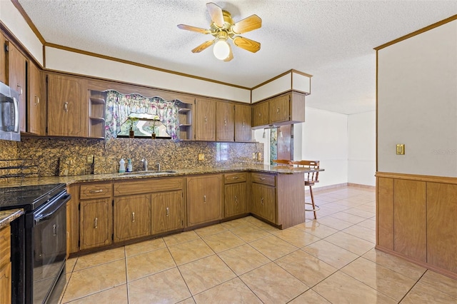 kitchen with light tile flooring, dark stone countertops, backsplash, and range with electric stovetop