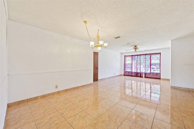 tiled spare room with ceiling fan with notable chandelier and a textured ceiling