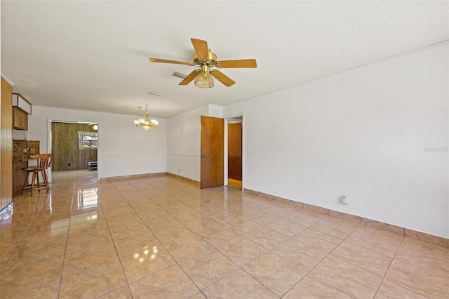 unfurnished room with light tile flooring, ceiling fan with notable chandelier, and a textured ceiling