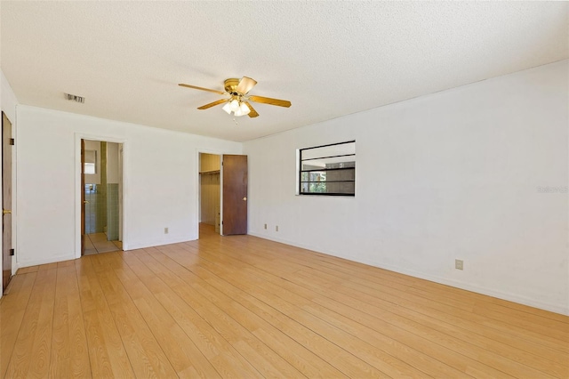 empty room with light hardwood / wood-style flooring, ceiling fan, and a textured ceiling