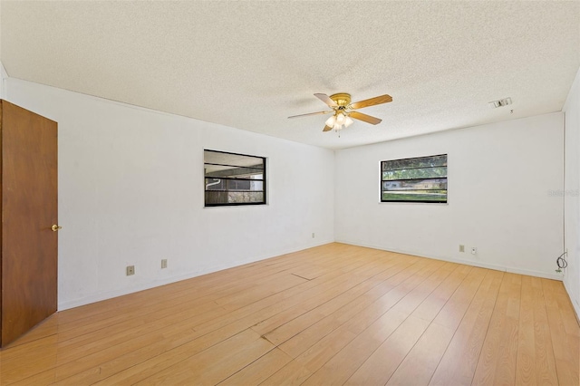 empty room with light hardwood / wood-style flooring, ceiling fan, and a textured ceiling