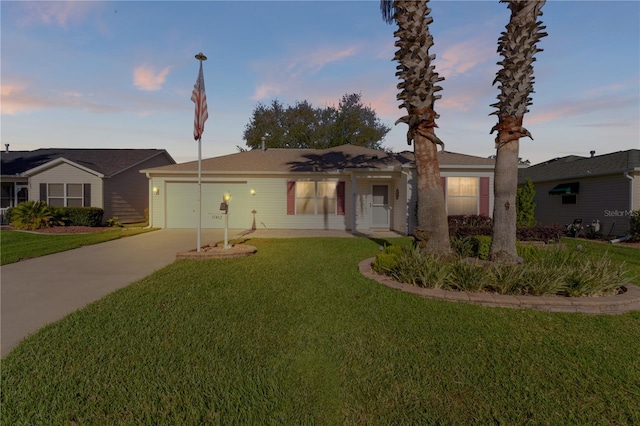 ranch-style home with a yard and a garage