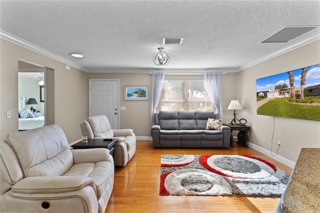 living room with a textured ceiling, ornamental molding, ceiling fan, and light wood-type flooring