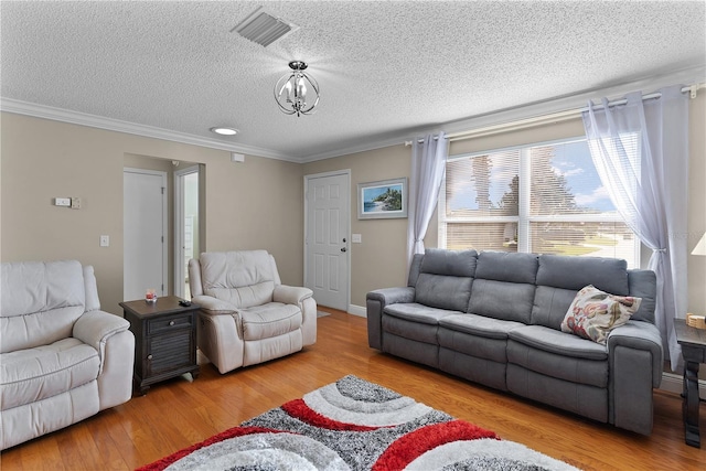 living room featuring ornamental molding, a textured ceiling, a chandelier, and light wood-type flooring