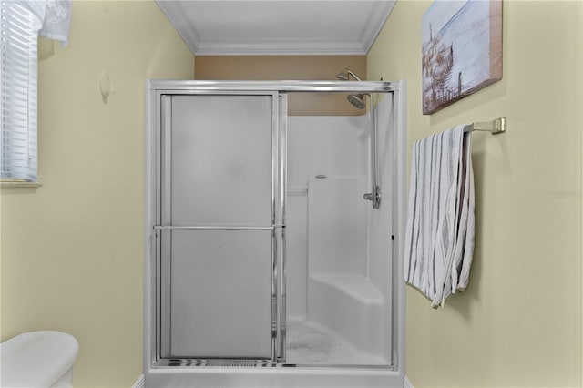 bathroom with crown molding, toilet, a textured ceiling, and a shower with door