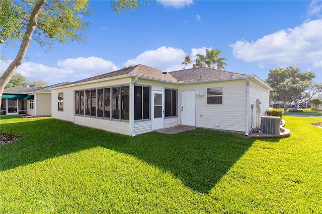 rear view of house featuring a lawn and a sunroom