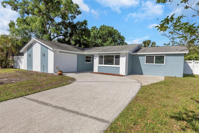 ranch-style home with a garage and a front lawn