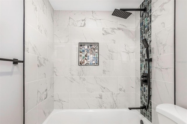 bathroom featuring tiled shower / bath and toilet