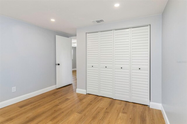 unfurnished bedroom featuring light hardwood / wood-style flooring and a closet