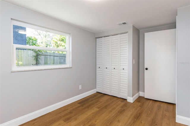 unfurnished bedroom featuring a closet and light wood-type flooring