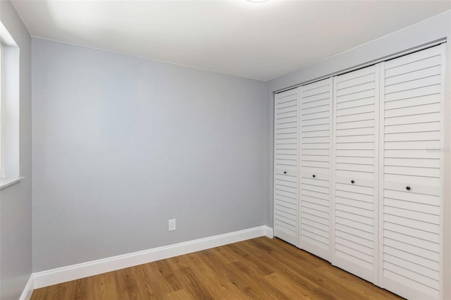 unfurnished bedroom with hardwood / wood-style flooring and a closet