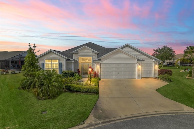 ranch-style house featuring a garage and a lawn