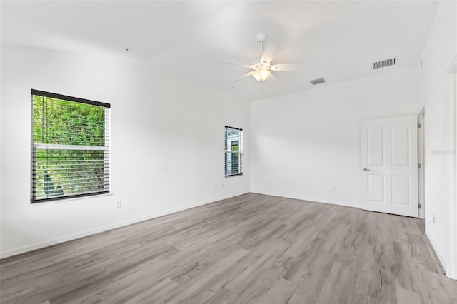 spare room featuring vaulted ceiling, light hardwood / wood-style flooring, and ceiling fan