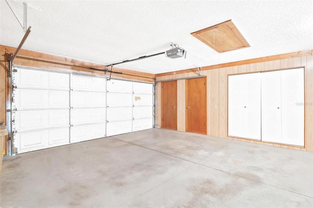 garage with wooden walls and a garage door opener