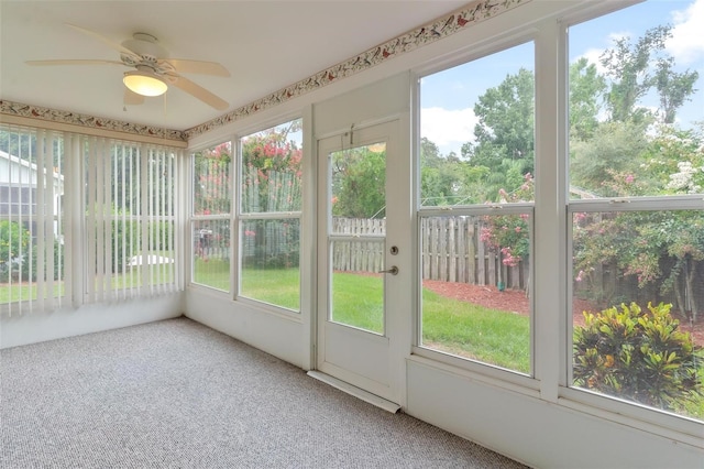 unfurnished sunroom featuring ceiling fan