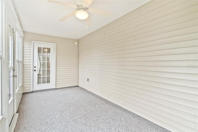 unfurnished sunroom featuring ceiling fan