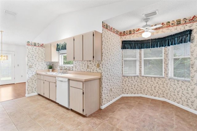 kitchen featuring white dishwasher, vaulted ceiling, ceiling fan, sink, and cream cabinetry