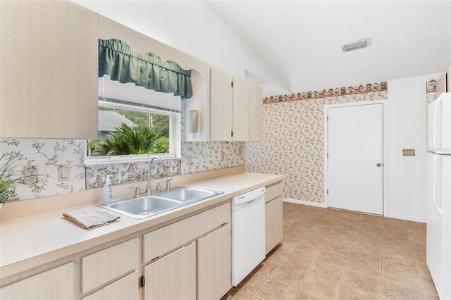 kitchen with white appliances, sink, and vaulted ceiling