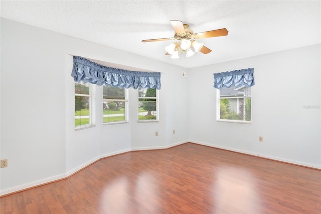 spare room featuring a textured ceiling, hardwood / wood-style flooring, plenty of natural light, and ceiling fan