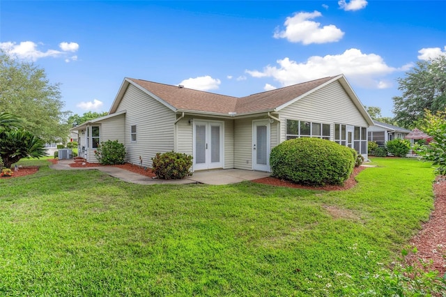 exterior space with french doors, a yard, and central AC unit