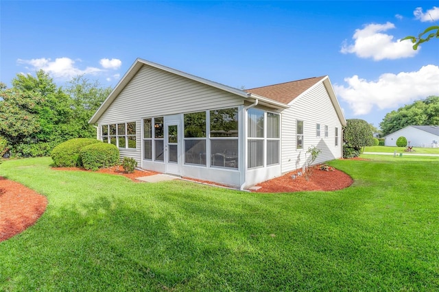 back of house featuring a sunroom and a yard