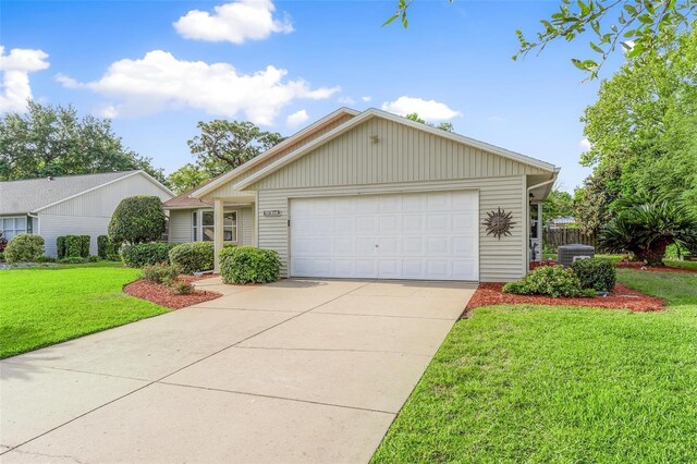 view of front of house with a garage, a front lawn, and central air condition unit