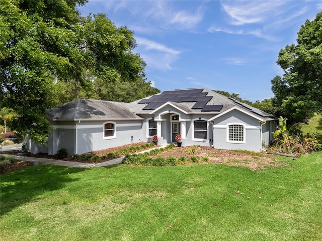 view of front facade featuring a front yard and solar panels