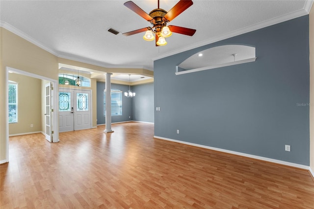 spare room featuring light hardwood / wood-style flooring, ceiling fan with notable chandelier, a textured ceiling, ornate columns, and ornamental molding