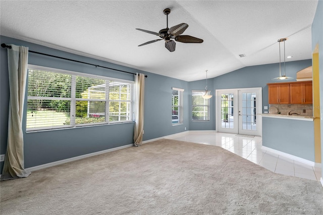 spare room featuring lofted ceiling, french doors, ceiling fan, and light carpet