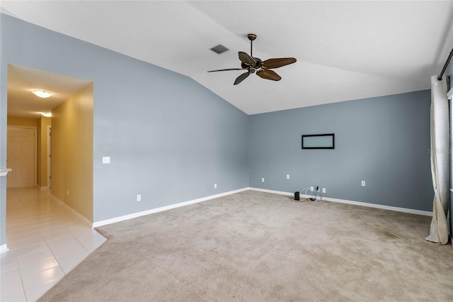 tiled empty room featuring vaulted ceiling and ceiling fan