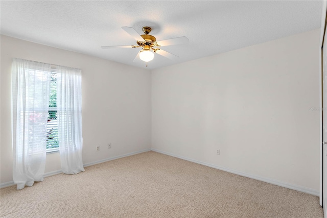 carpeted empty room with ceiling fan and a textured ceiling