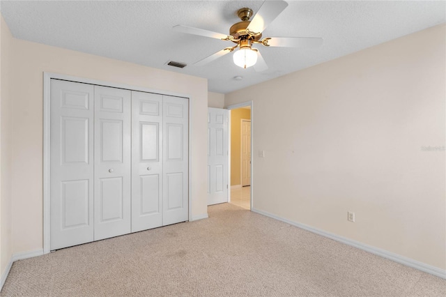 unfurnished bedroom with a closet, ceiling fan, and light carpet