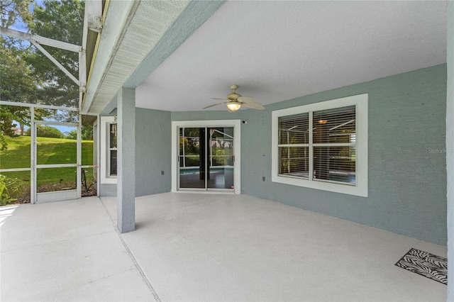 unfurnished sunroom with ceiling fan