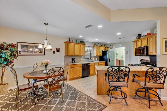 kitchen featuring a kitchen island, tasteful backsplash, black appliances, and light tile floors