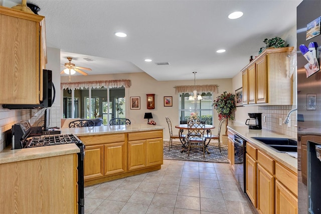 kitchen with range with gas stovetop, backsplash, hanging light fixtures, ceiling fan with notable chandelier, and sink