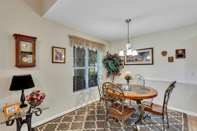 tiled dining room featuring an inviting chandelier