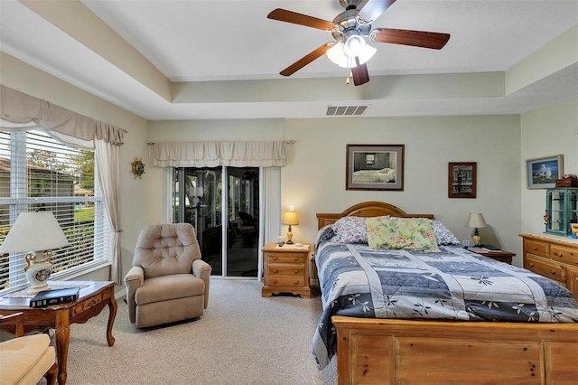 bedroom with light colored carpet, a raised ceiling, ceiling fan, and access to exterior