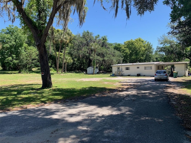 manufactured / mobile home featuring a shed and a front yard