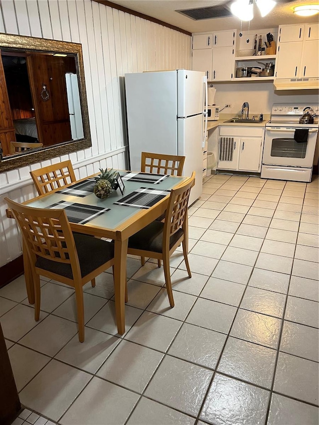 dining space with ceiling fan, sink, and light tile flooring