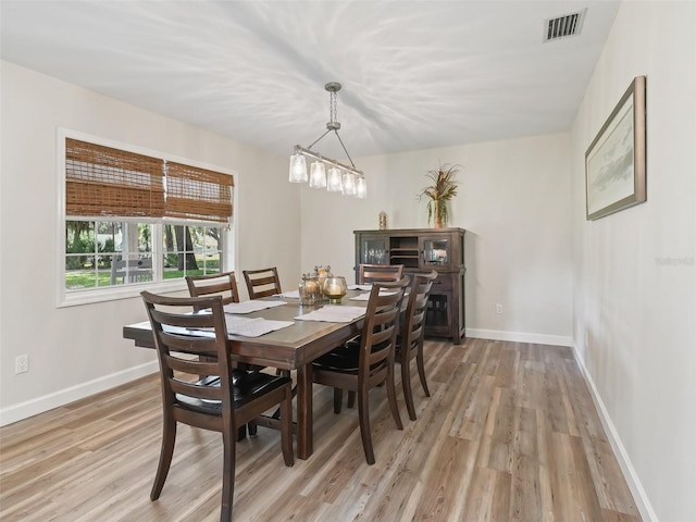 dining area featuring a notable chandelier and light hardwood / wood-style flooring