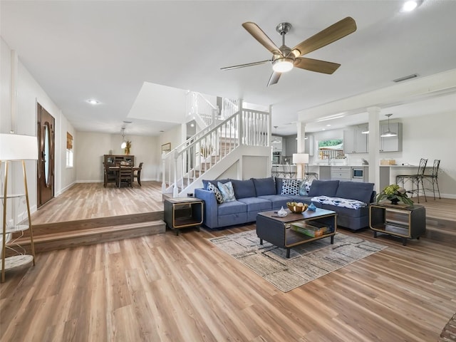 living room featuring light hardwood / wood-style floors and ceiling fan