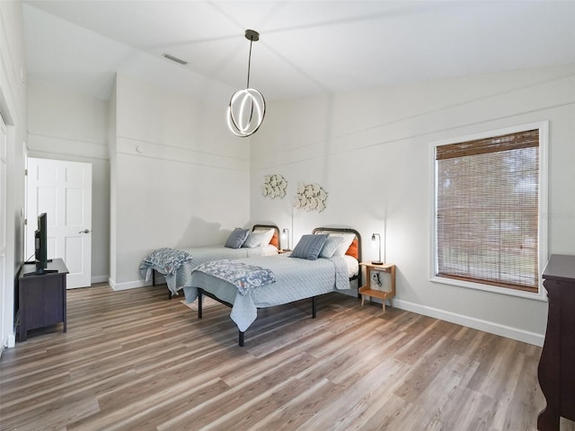 bedroom featuring wood-type flooring and vaulted ceiling