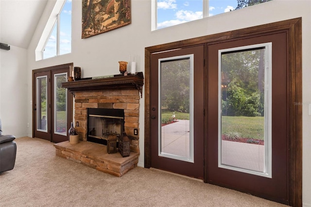 interior space featuring a fireplace, high vaulted ceiling, and carpet flooring