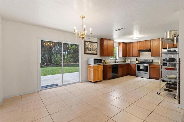 kitchen featuring pendant lighting, stainless steel appliances, light tile floors, and an inviting chandelier