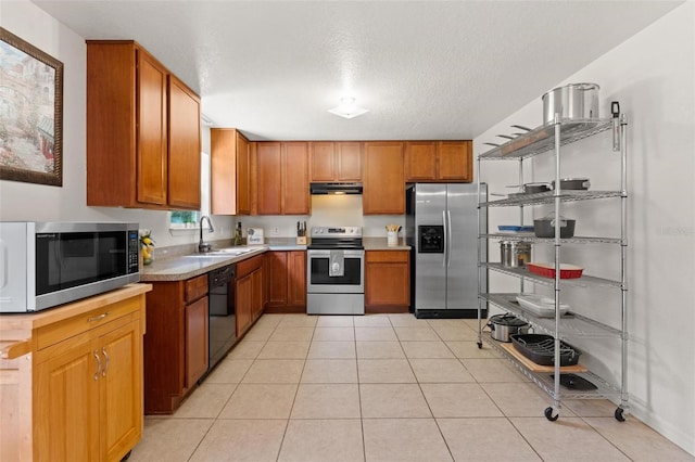 kitchen with light tile floors, a textured ceiling, sink, stainless steel appliances, and ventilation hood