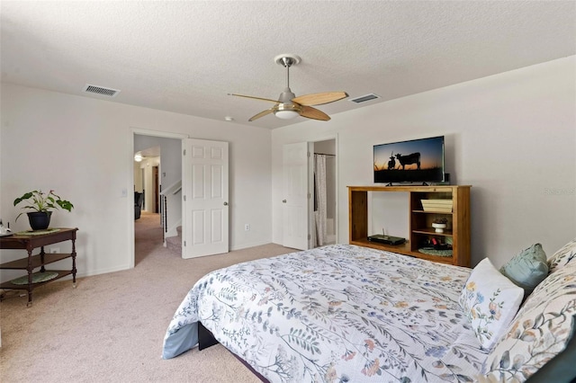 carpeted bedroom with ceiling fan and a textured ceiling