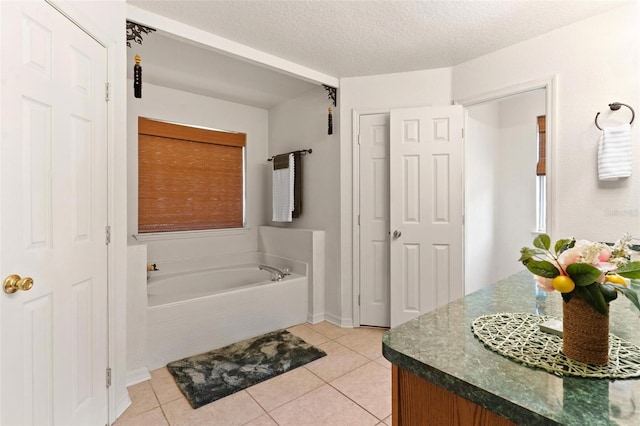 bathroom featuring a bath to relax in, tile flooring, vanity, and a textured ceiling