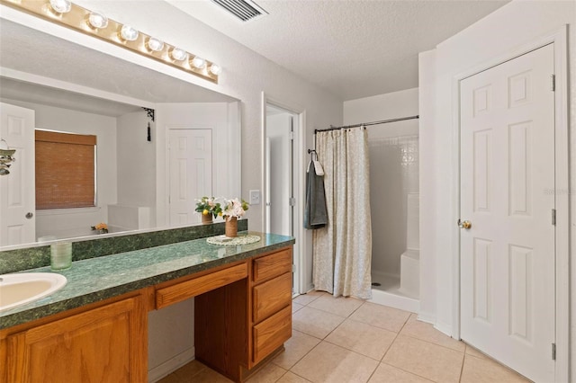 bathroom with tile flooring, curtained shower, dual vanity, and a textured ceiling