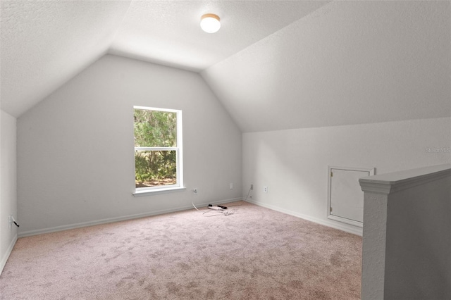 bonus room with light colored carpet, lofted ceiling, and a textured ceiling