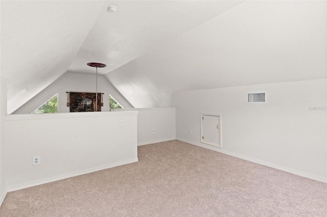 additional living space featuring carpet floors and vaulted ceiling